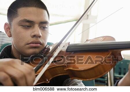 Stock Photo - Hispanic student practicing on violin. Fotosearch
