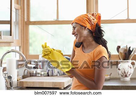 Stock Photo - Hispanic woman cleaning kitchen. Fotosearch