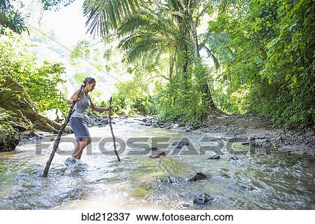 Hispanic woman crossing jungle stream View Large Photo Image Stock Photo - Hispanic woman crossing jungle stream. Fotosearch