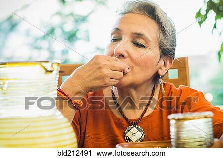 Hispanic woman eating in restaurant View Large Photo Image Stock Image - Hispanic woman eating in restaurant. Fotosearch