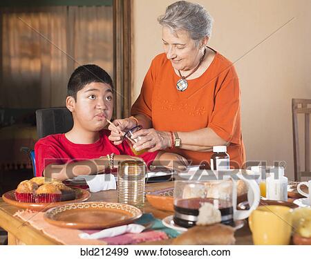 Hispanic woman helping grandson drink through straw View Large Photo Image Stock Photo - Hispanic woman helping grandson drink through straw. Fotosearch