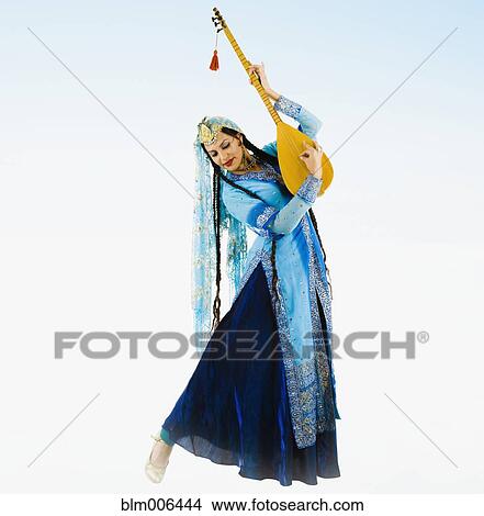 Hispanic woman in ornate dress playing musical instrument View Large Photo Image Picture - Hispanic woman in ornate dress playing musical instrument. Fotosearch