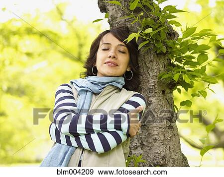Hispanic woman leaning against tree with eyes closed View Large Photo Image Stock Photo - Hispanic woman leaning against tree with eyes closed. Fotosearch