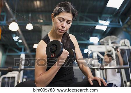 Hispanic woman lifting weights View Large Photo Image Stock Image - Hispanic woman lifting weights. Fotosearch