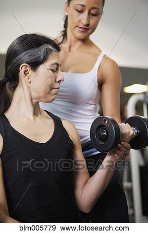 Stock Photo - Hispanic woman lifting weights. Fotosearch