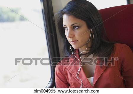 Hispanic woman listening to headphones on train View Large Photo Image Stock Photography - Hispanic woman listening to headphones on train. Fotosearch