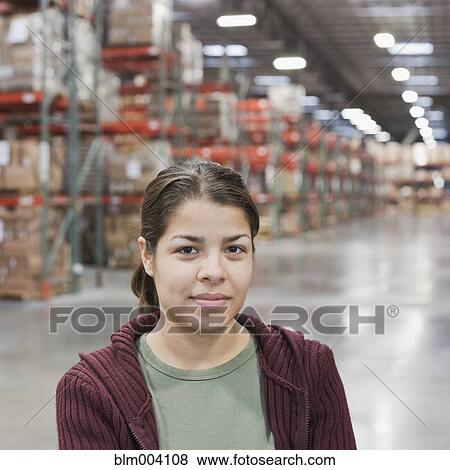 Hispanic woman smiling in warehouse View Large Photo Image Stock Photo - Hispanic woman smiling in warehouse. Fotosearch