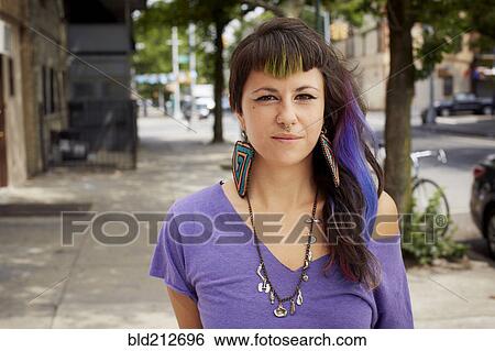 Stock Photograph - Hispanic woman standing on city street. Fotosearch