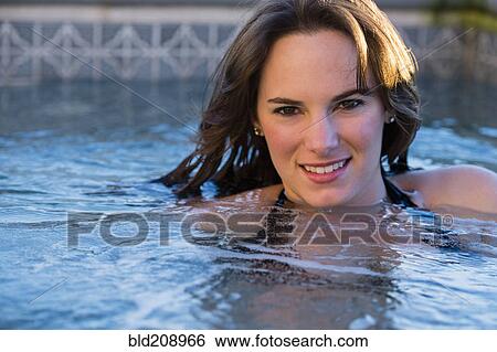 Stock Photograph - Hispanic woman swimming in pool. Fotosearch