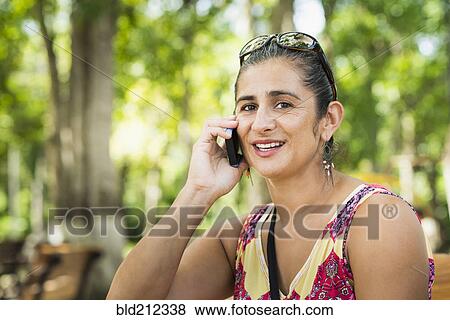 Stock Photo - Hispanic woman talking on cell phone. Fotosearch
