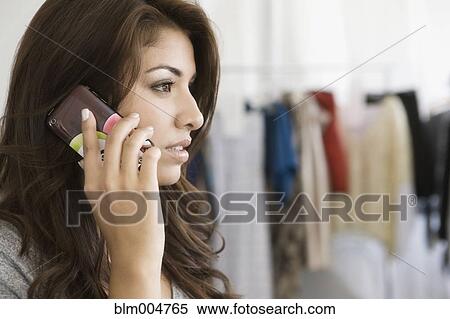 Stock Photography - Hispanic woman talking on cell phone. Fotosearch