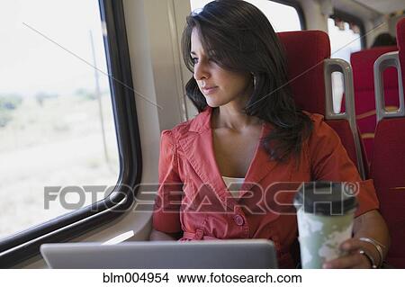 Hispanic woman using laptop on train View Large Photo Image Picture - Hispanic woman using laptop on train. Fotosearch