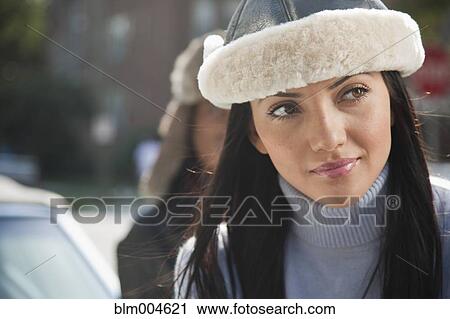 Stock Image - Hispanic woman wearing fur hat. Fotosearch