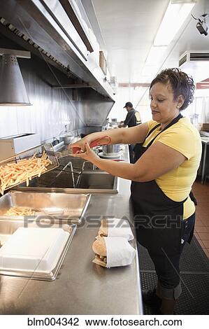 Stock Image - Hispanic woman working in diner kitchen. Fotosearch