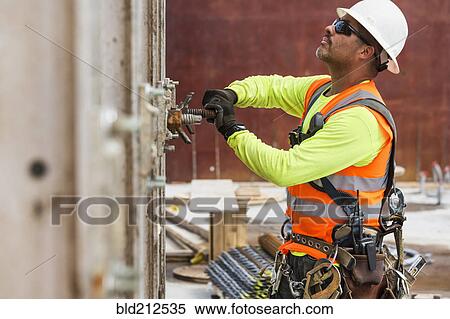 Stock Photography - Hispanic worker at construction site. Fotosearch