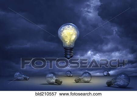 Stock Photo - Illuminated light bulb floating over dead bulbs. Fotosearch