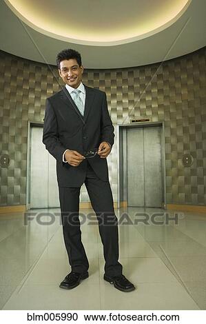 Stock Image - Indian businessman in office lobby. Fotosearch