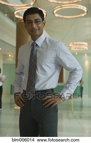 Indian businessman standing with hands on hips View Large Photo Image Picture - Indian businessman standing with hands on hips. Fotosearch