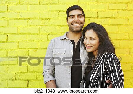 Indian couple hugging in front of yellow brick wall View Large Photo Image Stock Photo - Indian couple hugging in front of yellow brick wall. Fotosearch