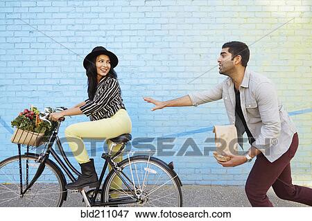 Indian man chasing girlfriend on bicycle View Large Photo Image Stock Photo - Indian man chasing girlfriend on bicycle. Fotosearch