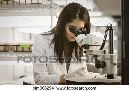 Picture - Indian scientist using microscope in laboratory. Fotosearch