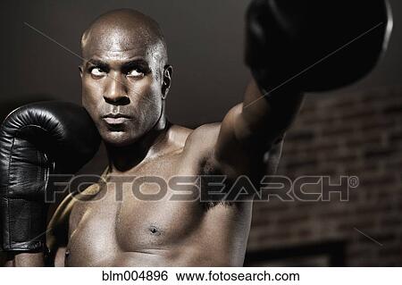 Intense African boxer punching View Large Photo Image Stock Photograph - Intense African boxer punching. Fotosearch