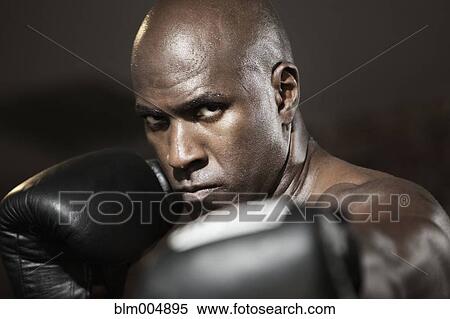 Stock Photography - Intense African boxer with arms raised. Fotosearch