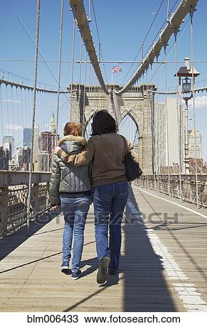 Stock Image - Italian couple crossing Brooklyn Bridge. Fotosearch