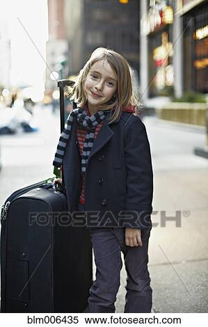 Stock Photography - Italian girl with suitcase on urban sidewalk. Fotosearch