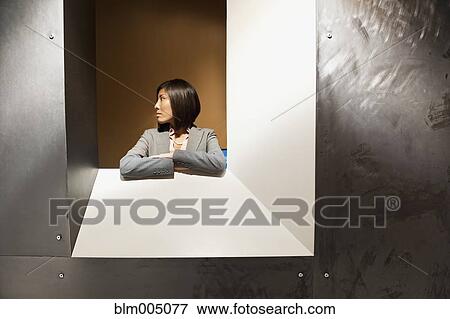 Stock Photo - Japanese businesswoman looking out internal window. Fotosearch