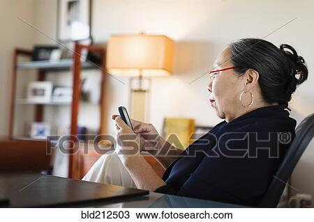 Japanese businesswoman using cell phone at desk View Large Photo Image Stock Image - Japanese businesswoman using cell phone at desk. Fotosearch