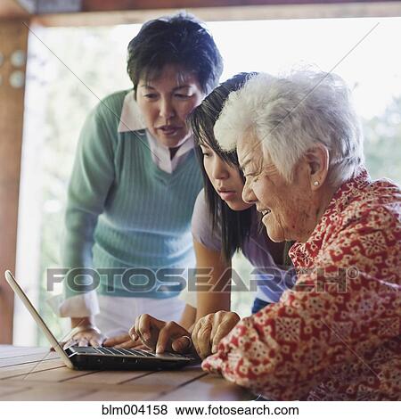 Japanese girl helping grandmother use laptop View Large Photo Image Stock Photo - Japanese girl helping grandmother use laptop. Fotosearch