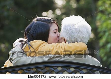 Stock Image - Japanese girl kissing grandmother. Fotosearch