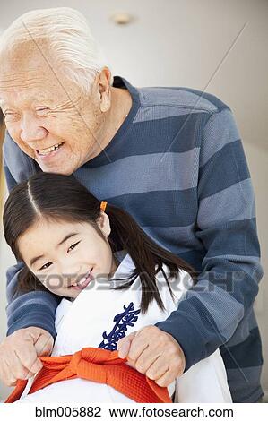Japanese grandfather helping granddaughter with karate uniform View Large Photo Image Stock Image - Japanese grandfather helping granddaughter with karate uniform. Fotosearch