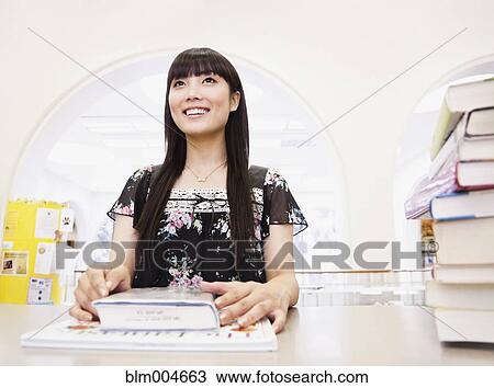Japanese woman with books in library View Large Photo Image Stock Image - Japanese woman with books in library. Fotosearch