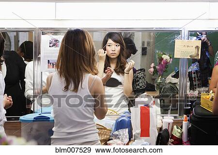 Korean girl putting makeup on backstage View Large Photo Image Stock Photo - Korean girl putting makeup on backstage. Fotosearch