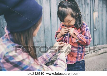 Korean mother helping daughter button her shirt View Large Photo Image Stock Image - Korean mother helping daughter button her shirt. Fotosearch