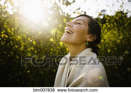 Laughing mixed race woman with eyes closed in field View Large Photo Image Stock Photo - Laughing mixed race woman with eyes closed in field. Fotosearch
