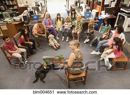 Librarian reading book to group of children View Large Photo Image Stock Image - Librarian reading book to group of children. Fotosearch
