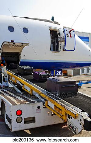 Luggage on conveyor belt by airplane cargo hold View Large Photo Image Stock Photograph - Luggage on conveyor belt by airplane cargo hold. Fotosearch