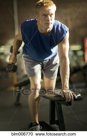 Man lifting weights in health club View Large Photo Image Stock Image - Man lifting weights in health club. Fotosearch