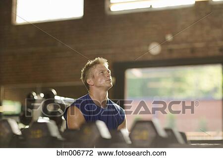 Man lifting weights in health club View Large Photo Image Stock Image - Man lifting weights in health club. Fotosearch