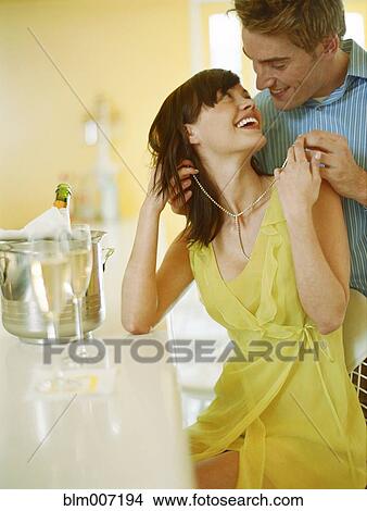 Man putting necklace on woman View Large Photo Image Picture - Man putting necklace on woman. Fotosearch