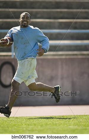 Man running with football View Large Photo Image Stock Image - Man running with football. Fotosearch