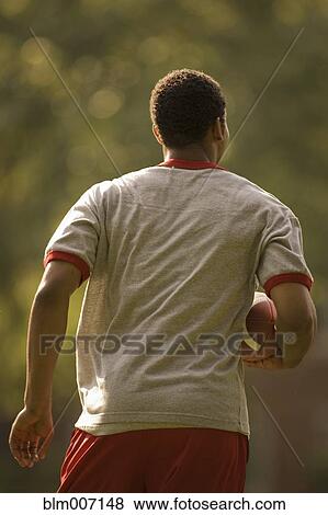 Stock Photo - Man running with football. Fotosearch