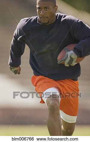 Man running with football View Large Photo Image Stock Photograph - Man running with football. Fotosearch