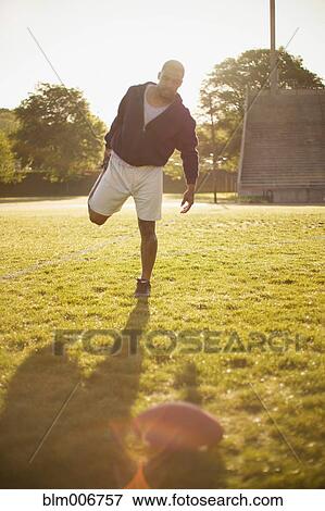 Man stretching on football field View Large Photo Image Stock Photo - Man stretching on football field. Fotosearch