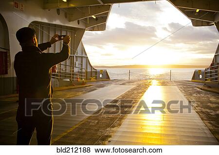 Stock Photo - Man taking picture out ferry gate. Fotosearch
