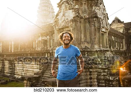 Stock Image - Man visiting ancient temple, Angkor, Siem Reap, Cambodia. Fotosearch