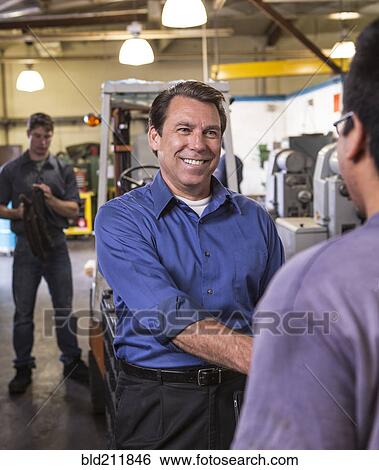 Manager and worker shaking hands in warehouse View Large Photo Image Stock Photograph - Manager and worker shaking hands in warehouse. Fotosearch